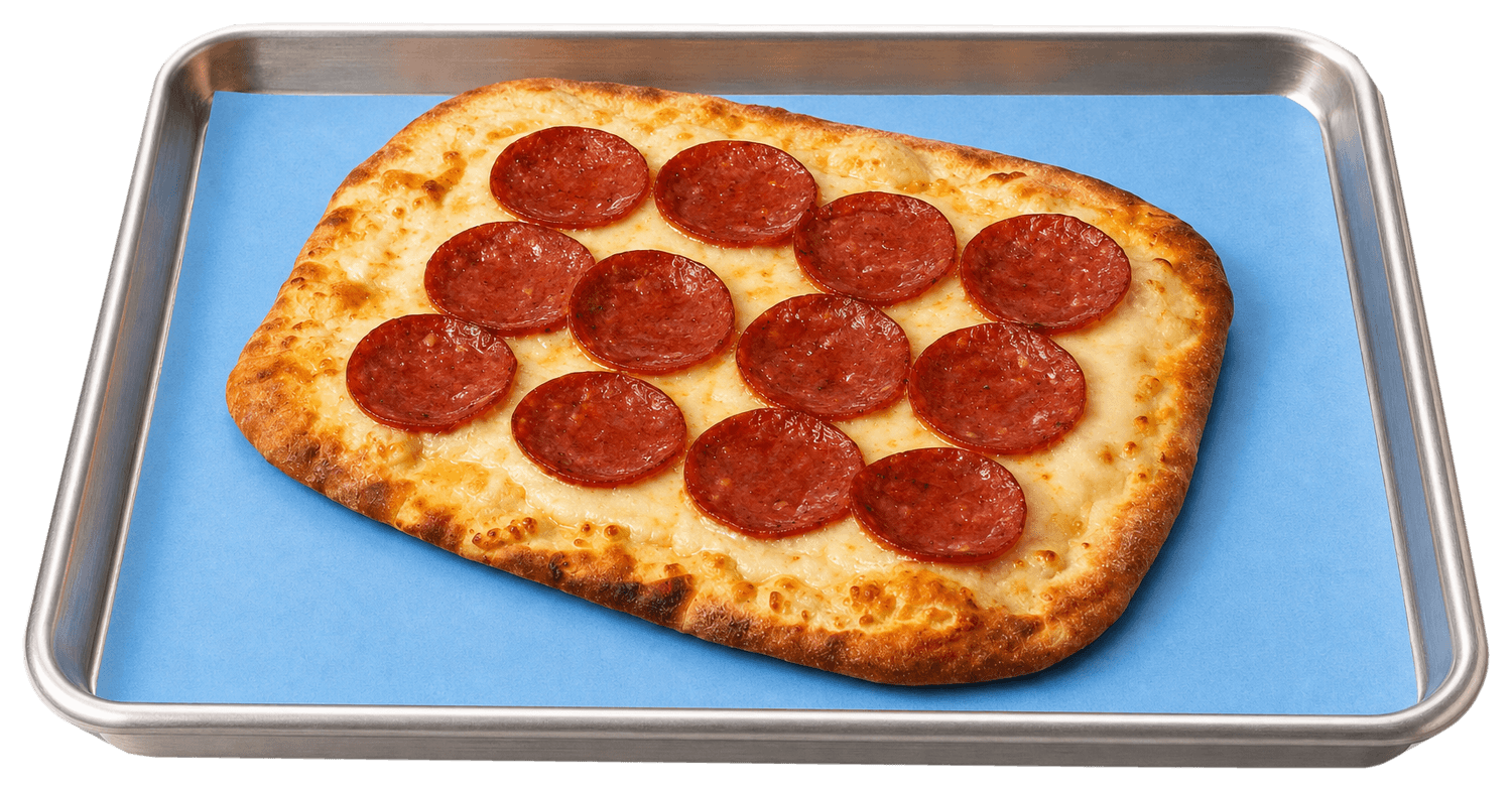 A pepperoni Crave Cut on a Crave baking tray lined with blue paper.
